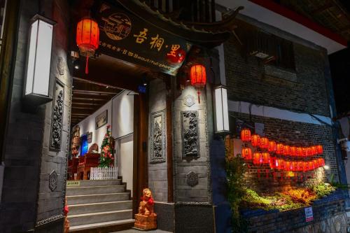 a building with lanterns on the side of it at Golden Dragon's Mountain Glow Inn Chinese Style Courtyard of Lijiang Ancient Town Close to main streets near by Dashiqiao Sifang Street,Big Water Wheels,We offer tickets purchasing services,Free station pick-up for three nights of,Provide nutritious brea in Lijiang