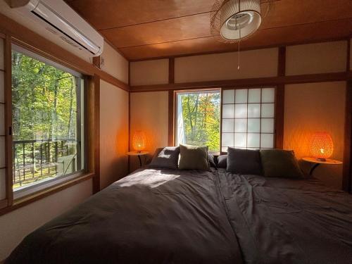 Ένα ή περισσότερα κρεβάτια σε δωμάτιο στο Kawa No Mori Villa Karuizawa - Ghibi-Like Enchanted Riverside Moss Garden Forest Retreat