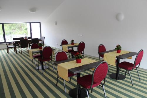 a waiting room with tables and red chairs at Helmers Gästehaus in Gempfing