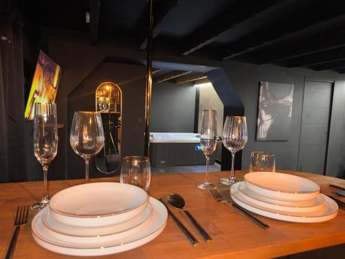 a wooden table with plates and wine glasses on it at SecretRoomBdx in Carbon-Blanc