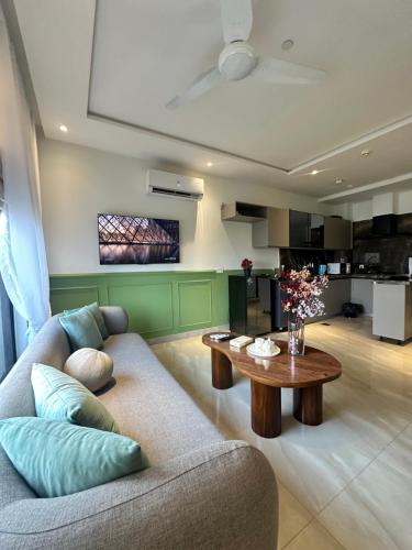 拉合尔Zameen aurum Luxury Apartment Gulberg 3 Mirhaa homes-3的客厅里有一张沙发和一张桌子。