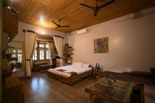 a living room with a bed and a couch at Paat Halodhiya Farm Stay in Kāhārpāra