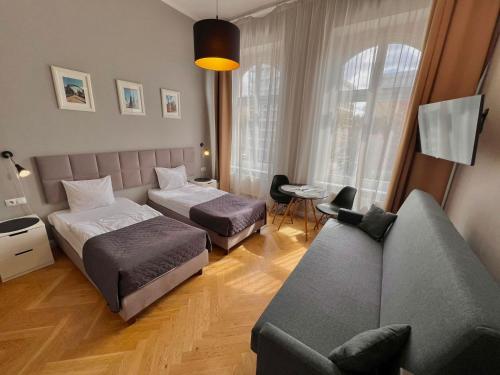 a hotel room with two beds and a couch at Wroclaw City Apartments in Wrocław