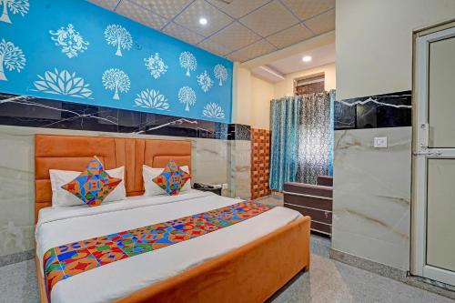 Un dormitorio con una cama y una pared azul. en Via Royal Plaza 62, en Noida