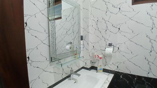 ein Badezimmer mit Waschbecken und Spiegel an der Wand in der Unterkunft Luna Villa in Mawadawila