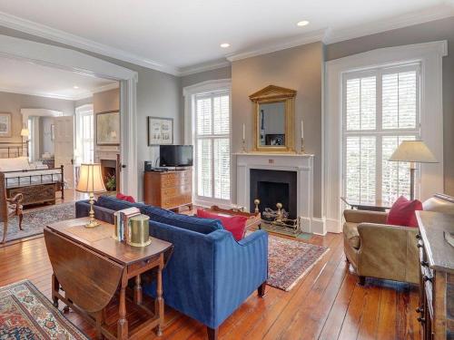 a living room with a blue couch and a fireplace at Bird Baldwin Twelve Oaks in Savannah