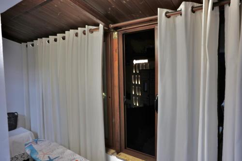 ein Schlafzimmer mit weißen Vorhängen und einem Fenster in der Unterkunft The Central Spot - Grand Suite in Tirana