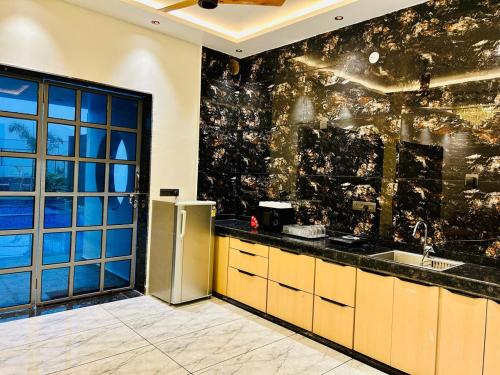 Black Rose 5 BHK Premium Luxurious villa في Nāi: مطبخ مع حوض وثلاجة