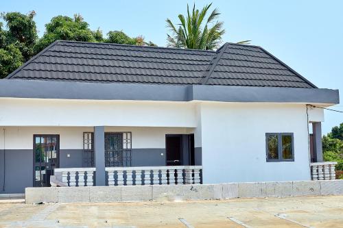 a white house with a black roof at Appartement meublé AKAPEO in Lomé