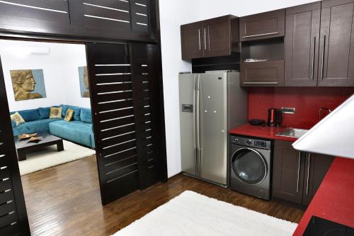 eine Küche und ein Wohnzimmer mit braunen Schränken in der Unterkunft The Central Spot - Grand Suite in Tirana