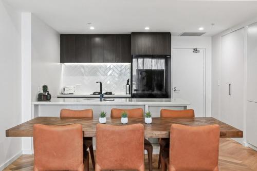 een keuken met een houten tafel en stoelen bij Serene Designer Stay in Sydney