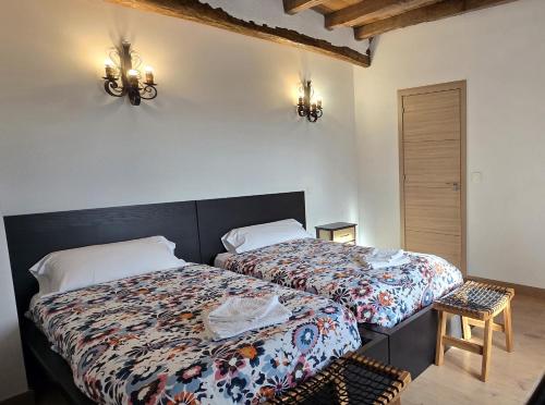 een slaapkamer met 2 bedden en een stoel bij Villa Rural Casa Alma in Castiltierra