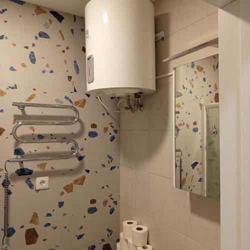 a bathroom with a toilet with a rock wall at VilniusCentralSpot in Vilnius