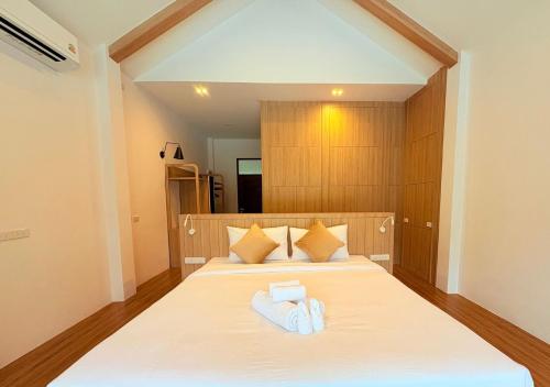 Un dormitorio con una cama con dos toallas encima. en The Poom Cafe & Resort Khao Yai, en Ban Khanong Phra Klang (1)