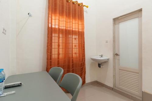 een kleine kamer met een tafel en een wastafel bij RedDoorz near UISU teladan Medan in Medan