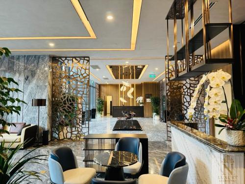 un hall d'hôtel avec des chaises et des tables dans l'établissement Lumiere Garden Hideaway, à Hô-Chi-Minh-Ville