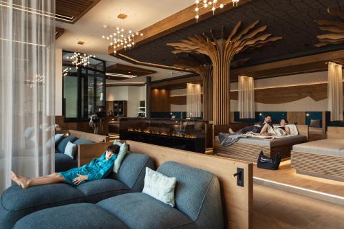 a woman laying on a couch in a hotel room at PACHMAIR 1453 apart resort in Uderns