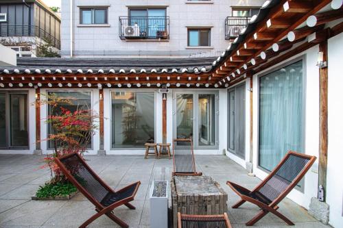 a patio with two chairs and a wooden table at 무료주차 스파 청량리 가족 독채 한옥 in Seoul