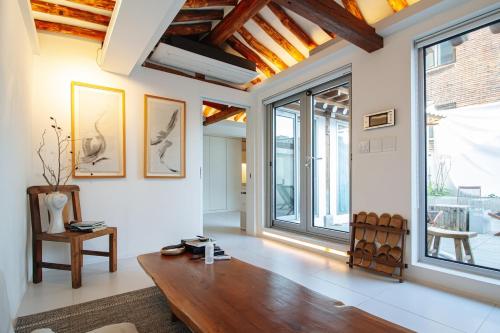 a living room with a wooden table and large windows at 무료주차 스파 청량리 가족 독채 한옥 in Seoul