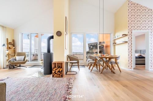 a living room with a table and chairs and a stove at Penthouse Kapitänskajüte, App 25 Olpenitz in Olpenitz