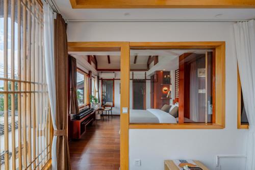 un dormitorio con una cama y un espejo en Lijiang Tongfu Inn, en Lijiang