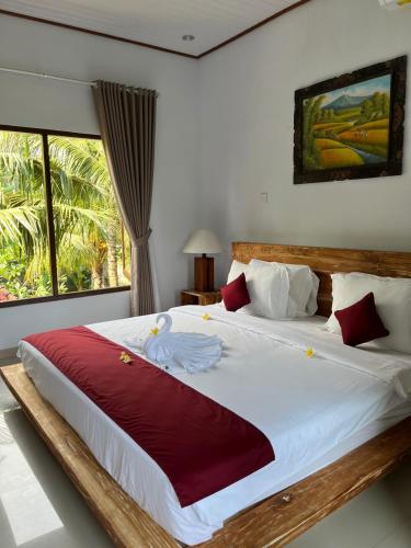 a bedroom with a large bed with a swan on it at Asli Bali Homestay in Candidasa