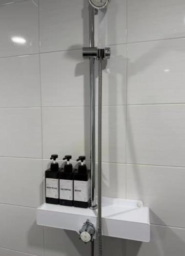 a bathroom with a shower with four bottles on a shelf at 대전 유천 샌디스테이 in Sŏdaejŏnuch'egug-yŏk