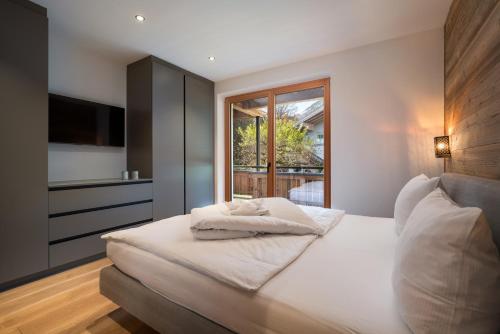 a bedroom with a large white bed with a window at Chalet Florian in Kirchberg in Tirol