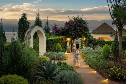 a person walking down a path in a garden at Dali Heartland Castle VILLA Cliffside Sea View Estate in Dali