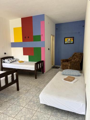 a room with two beds and a colorful wall at CASA DE LA ABUELA in Quixeré