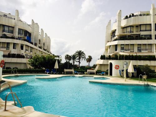 basen przed dwoma wysokimi budynkami w obiekcie Apartment Marbella House w Marbelli