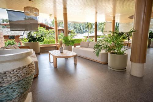 a living room with a couch and potted plants at Long Beach Chalet - SHA Extra Plus in Ko Lanta