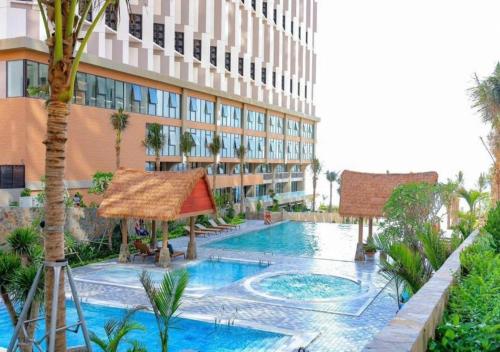 a resort with a swimming pool and a building at Beachfront Condotel - Free Pool Access - Apec Mandala Mui Ne in Ấp Thiẹn Ái