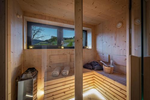 a sauna with a window in a wooden cabin at Steindlgut - Weinberg Chalets in Brixen