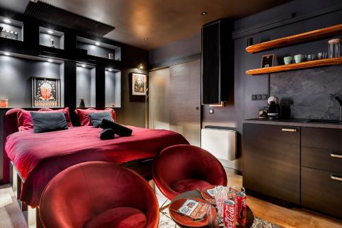 AuteriveLa cinemaRoom d'Auterive - Son Immersif Dolby et Atmos - Netflix的一间卧室，里面有红色椅子和铺着红色床单的床。