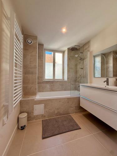 a bathroom with a tub and a sink and a mirror at Casa Luna Burgundy in Savigny-lès-Beaune