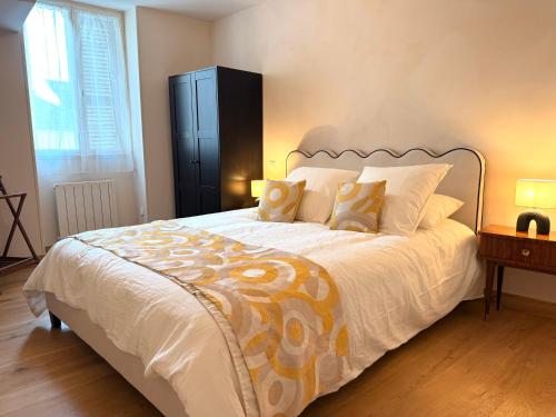 a bedroom with a large white bed with two pillows at Savigny les Beaune city center in Savigny-lès-Beaune