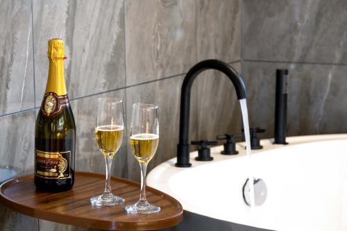 Zwei Gläser Wein auf einem Holztablett neben einem Waschbecken in der Unterkunft Golden Dragon's Mountain Glow Inn Chinese Style Courtyard of Lijiang Ancient Town English Speaking Service Close to main streets near by Dashiqiao Sifang Street,Big Water Wheels We offer private car service,tickets purchasing services in Lijiang