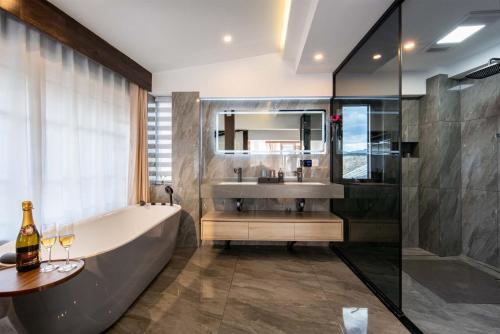 麗江市にあるGolden Dragon's Mountain Glow Innの浴槽、洗面台、鏡のあるバスルーム