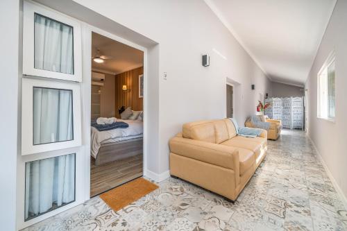 a living room with a couch and a bed at Orange Blossom Grove in Cerro das Taipas
