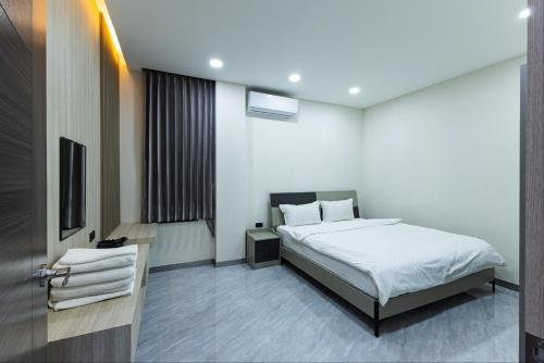 una habitación de hotel con una cama y un televisor en 다오 풀빌라, en Ban Nong-Heo