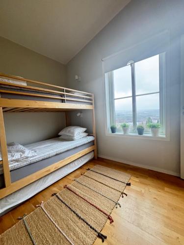 菲奈斯达伦Funäsdalsporten Röda Husen Funäsdalen的一间卧室设有双层床和窗户。