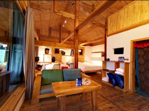 een woonkamer met een bank en een tafel bij 松潘怿宿古道牧风民宿Yisu in Songpan