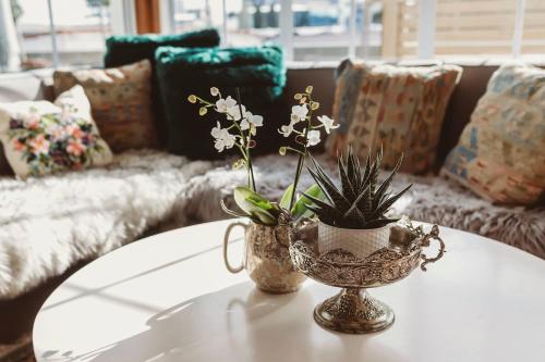 a coffee table with a vase with flowers on it at Timata Ora - 7BR family home in prime location in New Plymouth