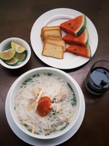 een tafel met borden met eten, noedels en brood bij Jennie's Apartment in Cat Ba