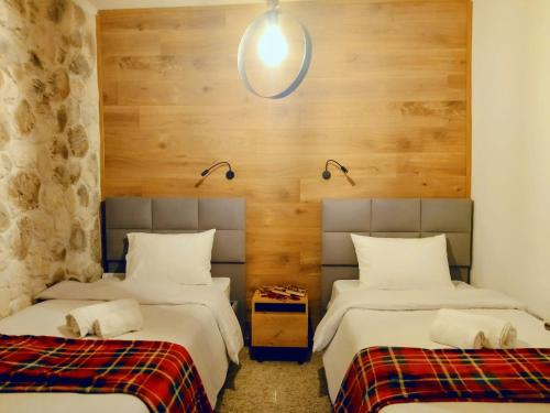 two beds in a room with wooden walls at G&J Traditional House in Elati Trikalon