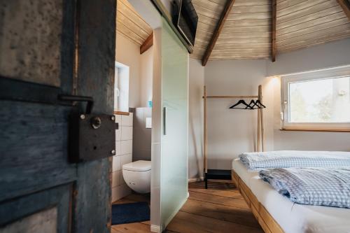 a bathroom with a bed and a toilet in a room at Ferienhaus Getreidesilo in Schneverdingen