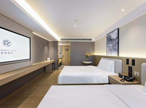a hotel room with two beds and a projection screen at Xingcheng Beijing Huilongguan Jishuitan Hospital Hotel in Beijing