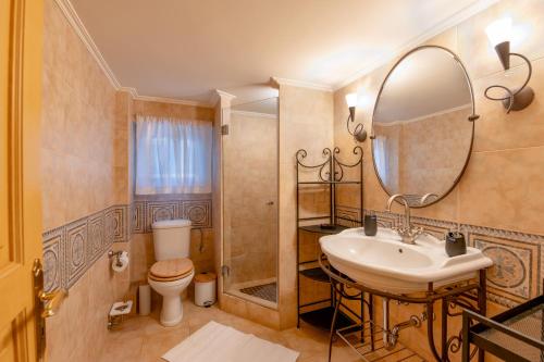 a bathroom with a sink and a toilet and a mirror at Villa Elmar in Aegina Town