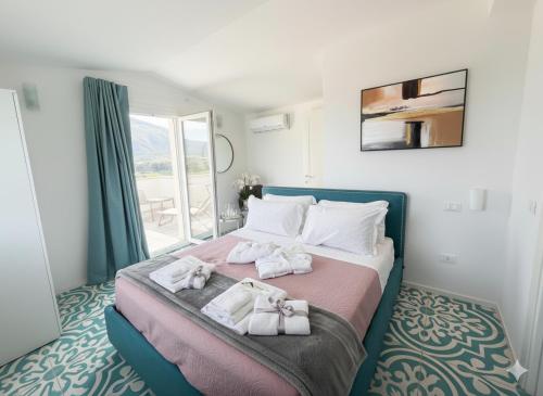 Un dormitorio con una cama con toallas. en Villa Verde Essence, en Castellammare del Golfo